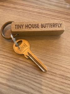 a pair of keys sitting on top of a wooden table at Lovin Göcek Tiny House Butterfly in Gökçeovacık