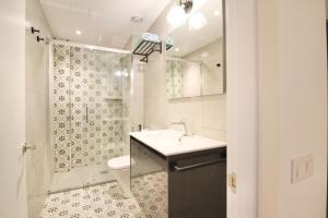 een badkamer met een wastafel, een toilet en een douche bij Mediterranean Way - Cavaller Suites in Tarragona