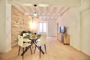 een eetkamer en een woonkamer met een tafel en stoelen bij Mediterranean Way - Cavaller Suites in Tarragona