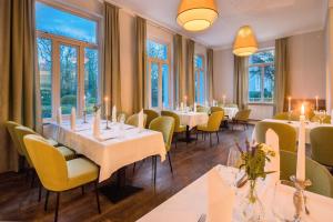 萬格羅格的住宿－Parkhotel Wangerooge，餐厅设有桌子和黄色的椅子以及窗户。