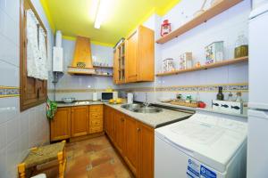 a small kitchen with wooden cabinets and a sink at Realejo Príncipe in Granada