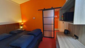 1 dormitorio con 2 camas y pared de color naranja en Camping Zeeburg Amsterdam, en Ámsterdam
