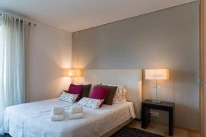 ヴィラモウラにあるMarina Vilamoura Penthouse Aquamar 606のベッドルーム1室(大きな白いベッド1台、枕2つ付)