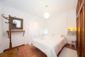 グラナダにあるRealejo Príncipeの白いベッドルーム(ベッド1台、鏡付)