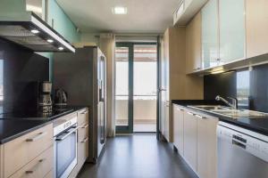ヴィラモウラにあるMarina Vilamoura Penthouse Aquamar 606の白い家電製品付きのキッチン、大きな窓