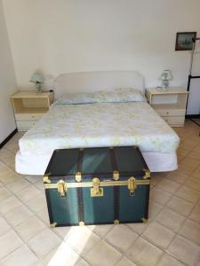 una maleta sentada en el suelo junto a una cama en Flat - Casale Angela en Bolsena