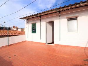 uma casa branca com um pátio de tijolos vermelhos em Loft Algavira em Sant Feliu de Guíxols