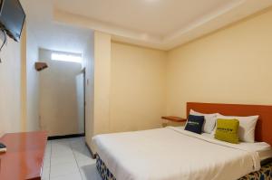 une chambre d'hôtel avec un lit et une télévision dans l'établissement Urbanview Hotel Syariah Residence Medan by RedDoorz, à Medan 25 autres photos