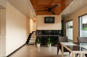 a living room with a ceiling fan and a table at Urbanview Hotel Syariah Residence Medan by RedDoorz in Medan