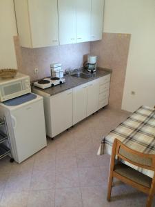 a kitchen with white cabinets and a sink and a microwave at Apartment Bertossin Rovini in Mošćenička Draga