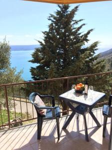 a table and chairs on a balcony with a view of the ocean at Apartment Bertossin Rovini in Mošćenička Draga