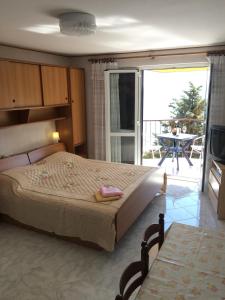 a bedroom with a large bed and a balcony at Apartment Bertossin Rovini in Mošćenička Draga