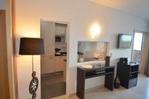 a living room with a desk and a kitchen at Marina Vilamoura Aquamar 301 By Vilamoura Sun in Vilamoura