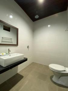 a bathroom with a white sink and a toilet at Best Star Resort in Pantai Cenang