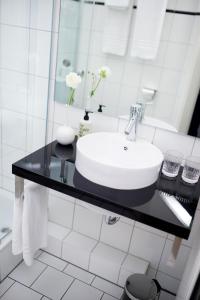 a white sink sitting under a mirror in a bathroom at Fritz im Pyjama in Hamburg