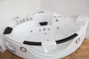 a white bath tub sitting on top of a wooden floor at Hotel Johannes Vermeer Delft in Delft