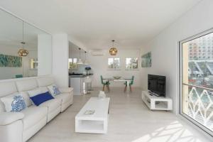 ein Wohnzimmer mit einem weißen Sofa und einem TV in der Unterkunft Boat View Marina Plaza By VilamouraSun in Vilamoura