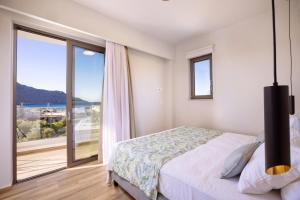 a bedroom with a bed and a large window at Zambia Luxury Apartments in Plakias