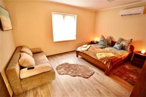 a living room with a bed and a couch at Bacchus Pub és Panzió in Dunaharaszti