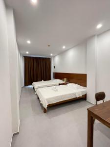 1 dormitorio con 2 camas y mesa. en Oceanism海洋主义潜水度假酒店 en Dumaguete