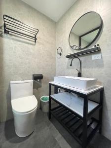 a bathroom with a white toilet and a mirror at Oceanism海洋主义潜水度假酒店 in Dumaguete