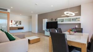 a kitchen and living room with a table and a couch at Marina Vilamoura Aquamar 120 By Vilamoura Sun in Vilamoura