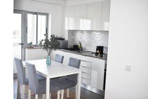 ファロにあるGrowIN Stay Downtownの白いテーブルと椅子のある白いキッチン +9枚の写真