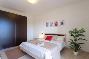 um quarto com uma grande cama branca com almofadas vermelhas em Casa a Telti by Wonderful Italy em Telti