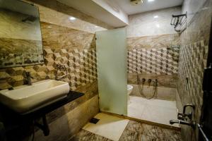 a bathroom with a sink and a shower at Hotel Sadbhav in Ahmedabad
