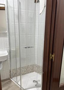 a shower with a glass door in a bathroom at Pension Norte in Portugalete