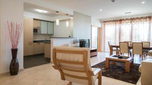 a living room with a kitchen and a dining room at Marina Vilamoura Aquamar 203 By Vilamoura Sun in Quarteira