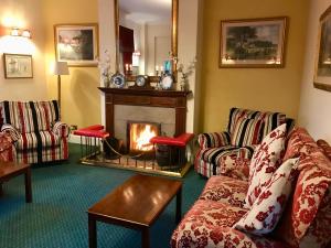 a living room with a couch and a fireplace at The Izaak Walton Country House Hotel in Ashbourne