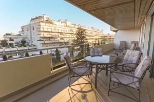a balcony with tables and chairs and a view of buildings at Marina Vilamoura - Aquamar 217 - By Vilamoura Sun in Quarteira