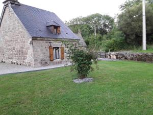 ein Steinhaus mit einem Baum davor in der Unterkunft La maison d oscar in Menet