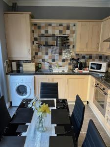 a kitchen with a table and chairs and a kitchen with a sink at Newbourne Terrace in Derby