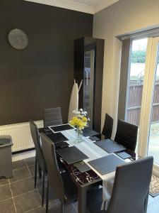 a dining room with a table with chairs and a clock at Newbourne Terrace in Derby