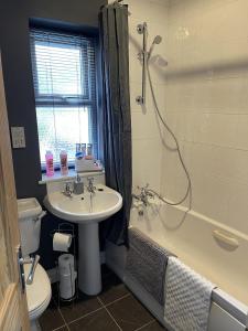 y baño con lavabo, bañera y aseo. en Newbourne Terrace en Derby