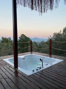 a hot tub on a wooden deck with a view at Lovin Göcek & Tiny House Lykia in Kertmeç