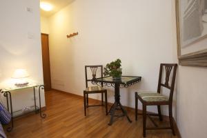 una habitación con una mesa con dos sillas y una planta en ella en Camere Carli, en Asís