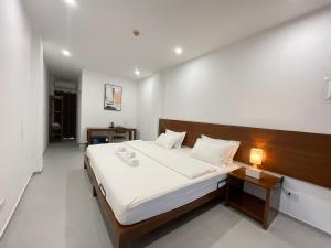 a bedroom with a large bed with a wooden headboard at Oceanism海洋主义潜水度假酒店 in Dumaguete