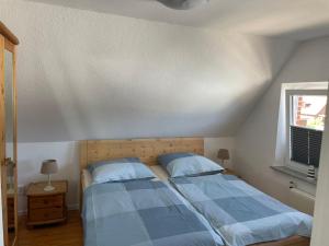 a bedroom with a bed with blue sheets and a window at Sanfte Brise-ideal für e-biker in Landkirchen