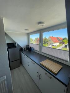 a kitchen with a counter and two large windows at Sanfte Brise-ideal für e-biker in Landkirchen