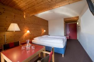 a bedroom with a bed and a table and a table sidx sidx sidx at Hotel Panorama in Hasliberg +45 photos