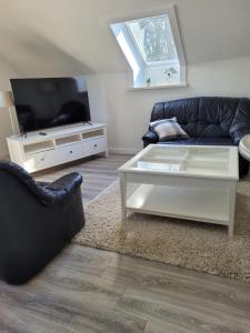 a living room with a couch and a tv at Ferienwohnung Prinzenpalais in Schleswig