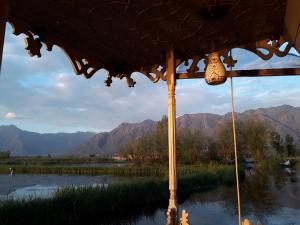 - une vue sur une rivière avec des montagnes en arrière-plan dans l'établissement Houseboat Zaindari Palace, à Srinagar