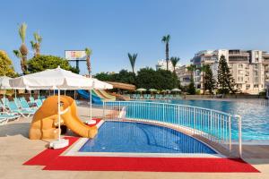 a swimming pool with a slide in front of a resort at Euphoria Comfort Beach Alanya in Mahmutlar