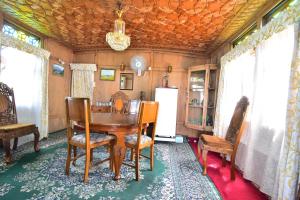 uma sala de jantar com uma mesa e cadeiras e um frigorífico em Houseboat Zaindari Palace em Srinagar