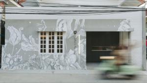 uma pessoa a passar de bicicleta por um mural num edifício em Dokdin's Family em Patong Beach