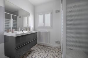 a white bathroom with a sink and a shower at Appartement à 650m de la plage ! in Le Pouliguen +7 photos