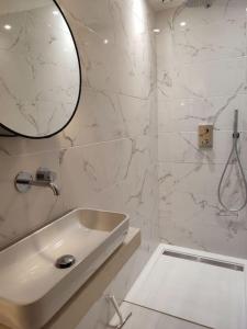 biała łazienka z umywalką i lustrem w obiekcie Pearl Studio by Halldis w Cannes